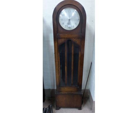 A 1930's oak arch top longcase clock with glazed door and triple weight driven chiming movement