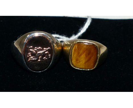 A gent's 9 carat hallmarked gold dress ring set with a tiger's eye, 3.7 gm; a gent's silver dress ring set with a gold colour