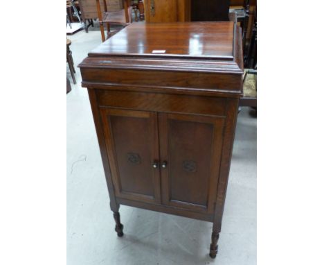 An oak floor standing windup record player with extra needles