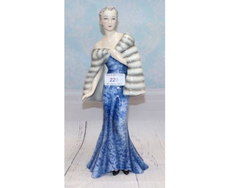 A Goldscheider figure designed by Claire Herczeg:  woman in long blue dress and fur wrap, impressed and signed in black, heig