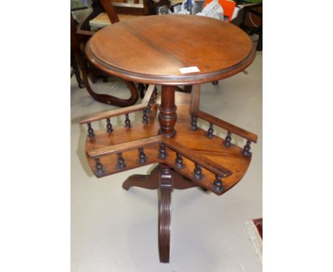 A Victorian mahogany tripod book table with circular top and galleried undertier