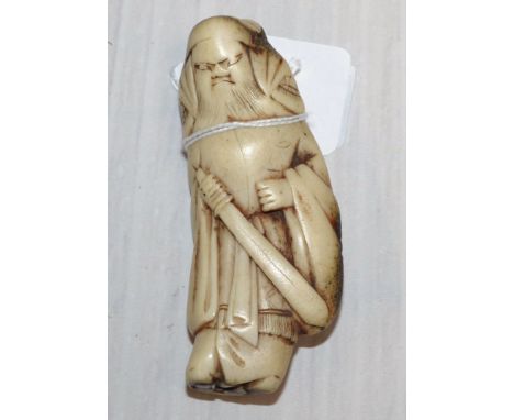 A Japanese netsuke of a bearded man with a sword, with label "Ex Collectis T.L. Elliott", 3½"
