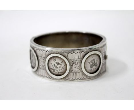 A BIRMINGHAM SILVER ENGRAVED BANGLE decorated with thistle rose and three leaf clover