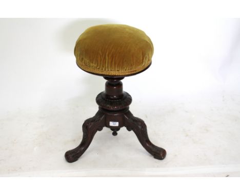 AN ANTIQUE CIRCULAR ADJUSTABLE STOOL on carved tripod support, the seat 32cm diameter