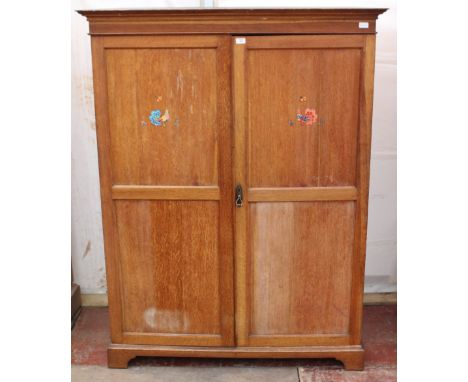 AN EARLY 20TH CENTURY LIGHT OAK WARDROBE with two doors and bracket feet, 131cm wide x 65cm deep x 173cm high