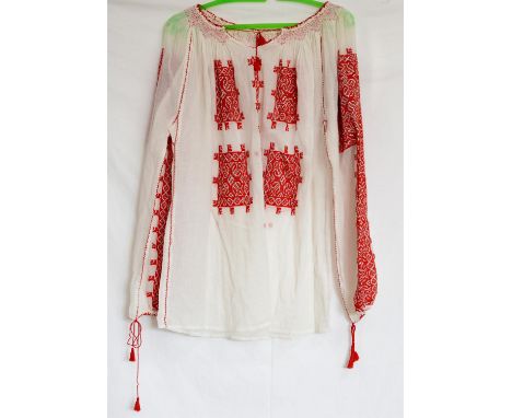 Traditional Romanian peasant blouse hand embroidered in blue cotton and white silk floss, together with another similar in re