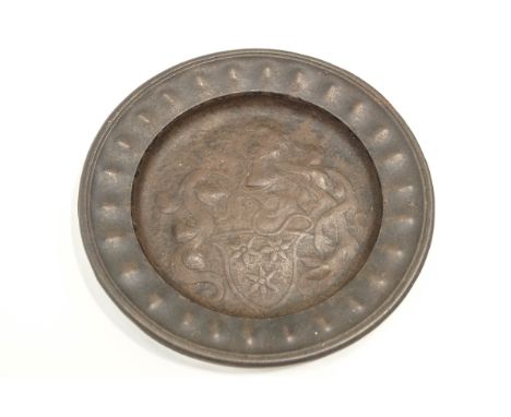 A cast iron Armorial plate, decorated with a central coat of arms, 25cm diameter