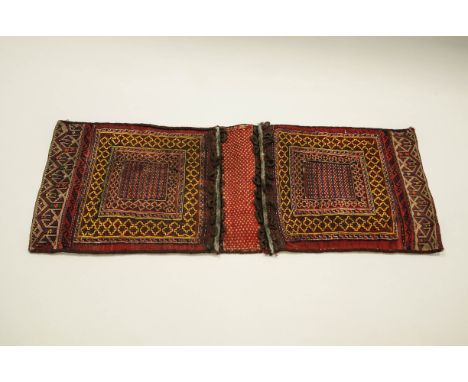 A large Arabian hand-woven saddle bag with twin geometric panel and palmette border, 42 x 122cms