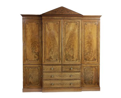 A LARGE REGENCY MAHOGANY BREAKFRONT WARDROBEEARLY 19TH CENTURYinlaid with ebonised stringing, the architectural pediment abov