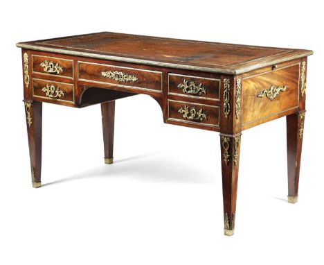 A FRENCH MAHOGANY AND ORMOLU MOUNTED BUREAU PLAT IN THE LOUIS XVI STYLE, FIRST HALF 19TH CENTURYthe top inset with a gilt too