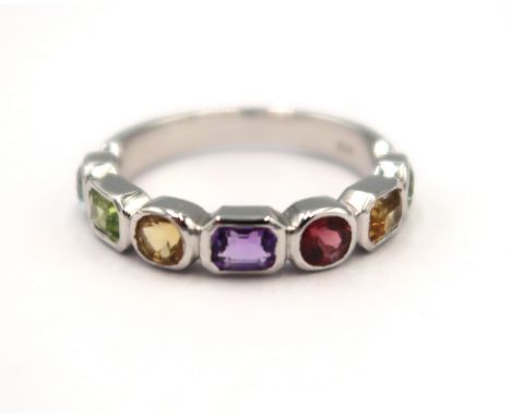 A 9ct white gold multi stone ring consisting of peridots, citrine, garnet, amethyst and aquamarine - ring size L/M