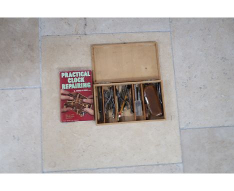 A box of watch makers tools with repair handbook.