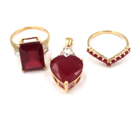 Three pieces of 9ct gold ruby jewellery. To include an eleven stone wishbone ring. Size M. A heart shape pendant with white z