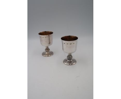 A pair of late 20th century silver goblets of simple form, with Celtic detail to the knopped stems, and gilt interiors,  Reid