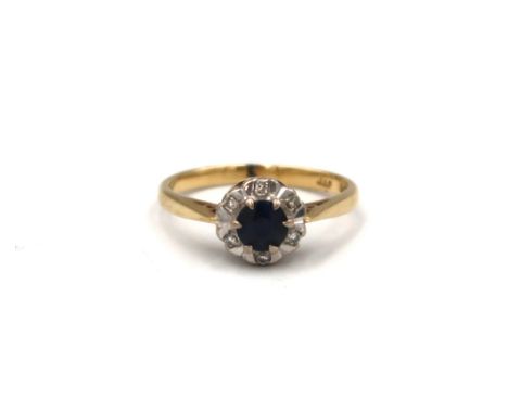 A sapphire and diamond daisy cluster ring. Size L. Stamped 18K. Weight 3.09 grams