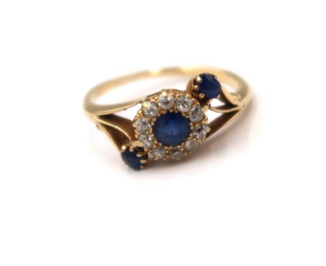 A sapphire and old cut diamond crossover cluster ring. Size L. Tests gold 18ct. Weight 2.50 grams