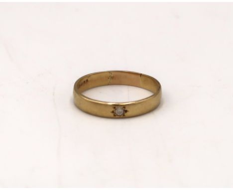 An 18ct gold band ring set with a brilliant cut diamond. Size S. Weight 3.14 grams.