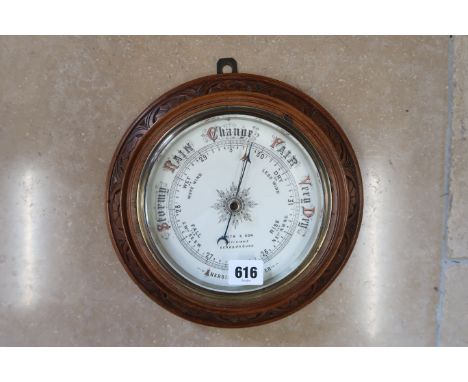 A circular barometer by S. Smith and Sons, Scarborough.