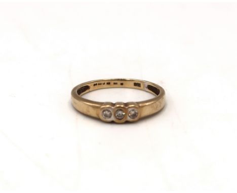 A 9ct gold brilliant cut diamond three stone ring. Size R. Weight 2.27 grams