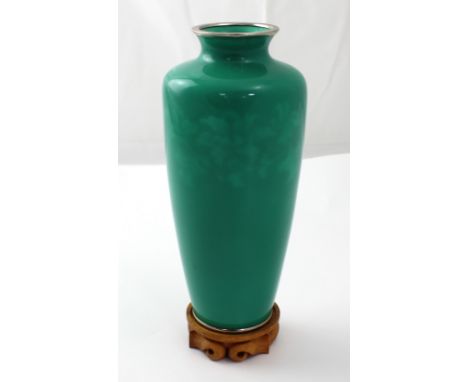 A Japanese jade enamelled elongated ovoid vase with ethereal floral decoration below the shoulder, height 21.5cm, on carved w