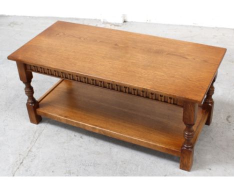 A modern prairie-style oak coffee table with egg and dart frieze over turned legs and shelf stretcher, 45 x 103cm.