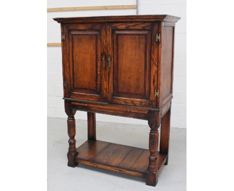 A modern 18th century style cabinet on stand, flared cornice above two mahogany cross-banded fielded panel doors, single shel