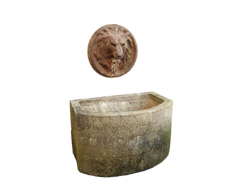 A cast iron lion mask wall mounting fountain head above an associated stone...  A cast iron lion mask wall mounting fountain 