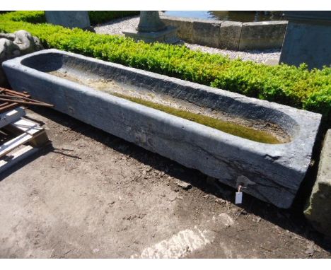 A rough hewn grey Bourgogne stone trough, 18th century, of rectangular section A rough hewn grey Bourgogne stone trough, 18th