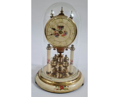 A revolving pendulum clock under glass dome. 
