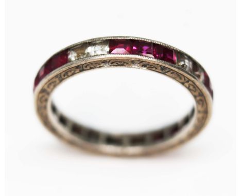 An antique white sapphire and ruby full eternity ring, engraved outer edge, channel set princess cut stones, unmarked gross w