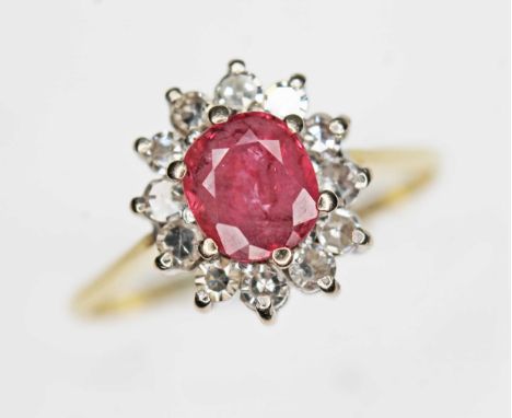 A ruby and diamond cluster ring, the oval cushion cut ruby weighing approx. 0.79ct, surround by twelve round cut diamonds wei