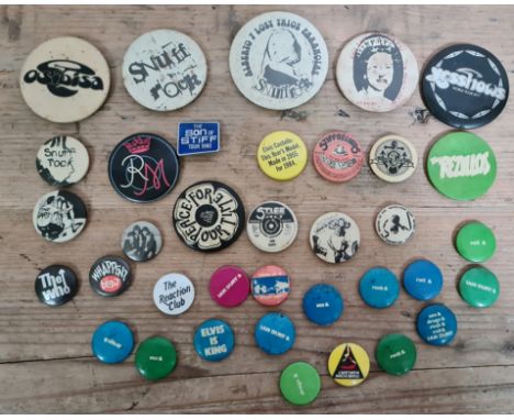 A collection of vintage music related pin badges to include Stiff records, Elvis Costello, Sex Pistols, The Who, Ian Dury and