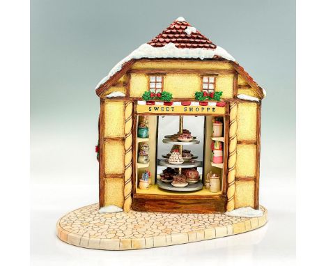 Festive Holiday Season resin display of a pastry shop. Detailed design with colorful jars of candy and a three-tier stand in 