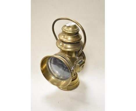 An antique brass Brown Brothers Veena oil coach lamp with handle and convex glass door.