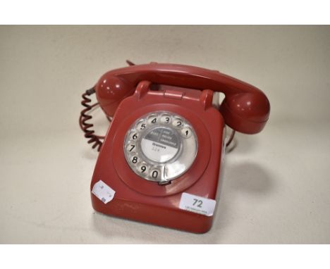 An iconic 1960s red rotary telephone.