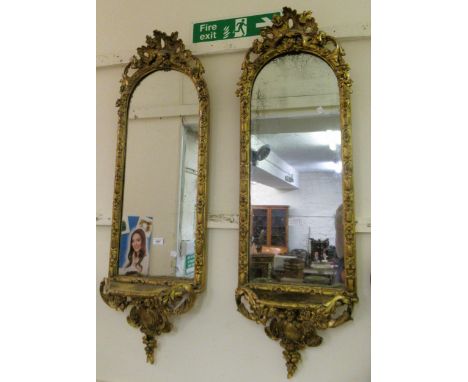 Pair of 19th Century French gilded composition wall mirrors, the arched tops with pierced floral surmounts, each with a small