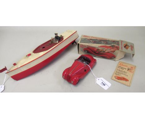 Schuco clockwork toy car in original box, together with a mid 20th Century tin plate clockwork model boatKey is not present b