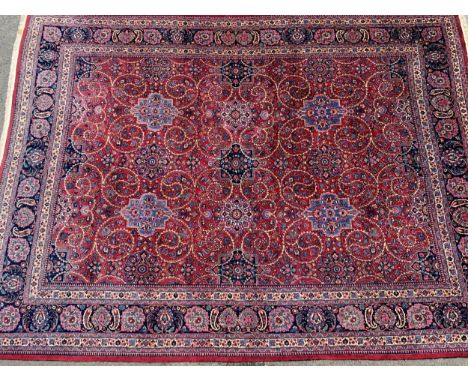 Tabriz carpet with an all-over stylised medallion and floral design on a red ground with palmette borders, 410 x 307cm, signa