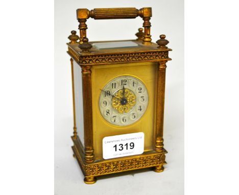 Early 20th Century ornate French gilt brass carriage clock, the circular silvered dial with arabic numerals  and with single 