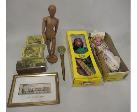 Brass paper knife, framed Stevengraph titled ' The Present Time ', two boxed Pelham puppets (at fault), small artist's ley fi