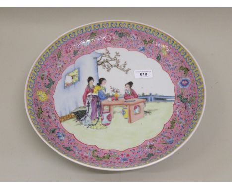 20th Century Chinese shallow circular wall plate decorated with figures in a garden scene, 34cm diameter, signed with red sea