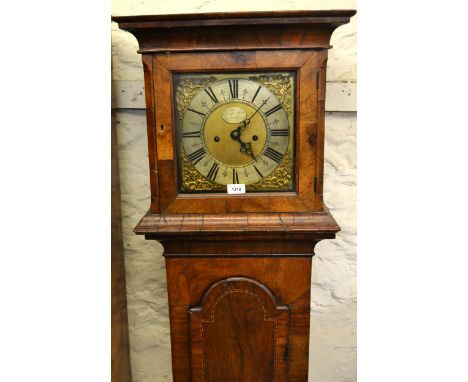 18th Century walnut and chequer inlaid longcase clock, the square hood above an arched door and a plinth base, the 10in brass