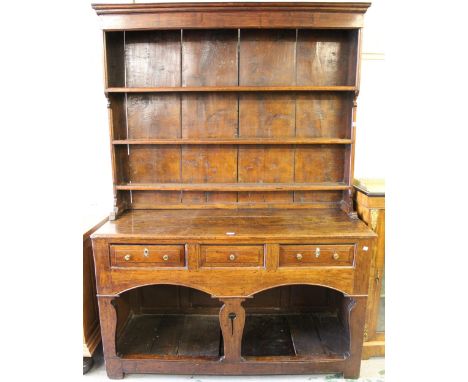 18th Century oak and elm dresser, the boarded shelf back above a moulded plank top, three fielded panel drawers, shaped pierc