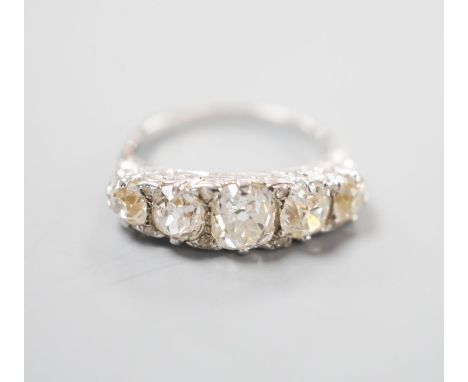 A white metal and graduated five stone old cut diamond set half hoop ring, with diamond chip spacers, size L, gross weight 3.