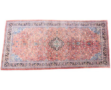 A TERRACOTTA GROUND FULL PILE PERSIAN SUROK RUNNER&nbsp; with dark central medallion and light blue spandrels on floral patte