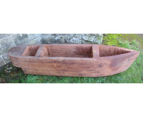 A carved wooden planter, formed as a boat, length 59ins, height 12.5ins