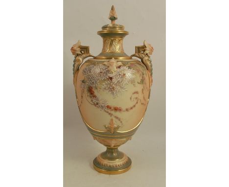 A Royal Worcester blush ivory vase, decorated with flowers to a blue/green ground, having mask handles and a cover, date code