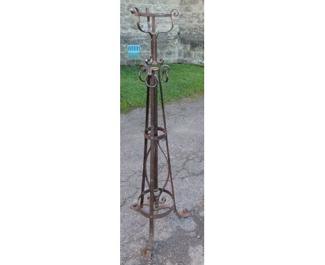 An Arts and Crafts style wrought iron and steel oil lamp stand, decorated with scrolls and rings, height 57ins