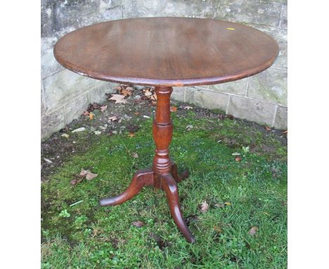 &nbsp;A 19th century oak tripod table, the circular top raised on a turned column, on three outswept supports, diameter 27ins