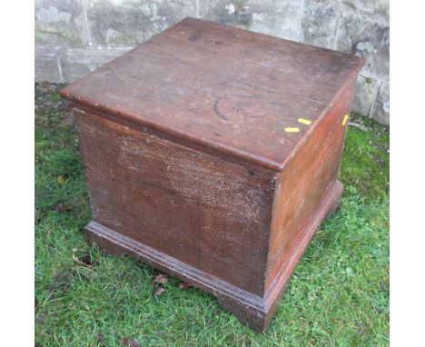 An oak box, with hinged rising lid, raised on bracket feet, 19.75ins x 19ins, height 19ins